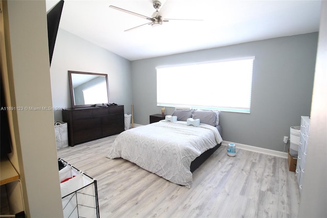 bedroom featuring ceiling fan, light hardwood / wood-style flooring, and lofted ceiling