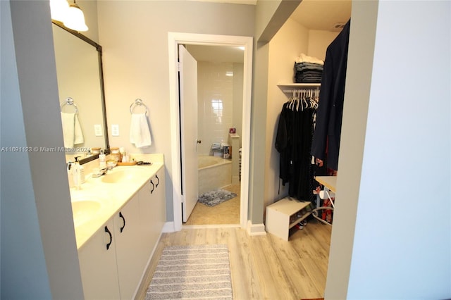 bathroom featuring hardwood / wood-style floors, tiled shower / bath combo, and vanity