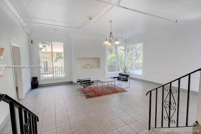 unfurnished living room with light tile patterned floors, an inviting chandelier, and ornamental molding