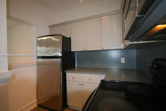 kitchen with decorative backsplash, stainless steel fridge, white cabinetry, and black electric range oven