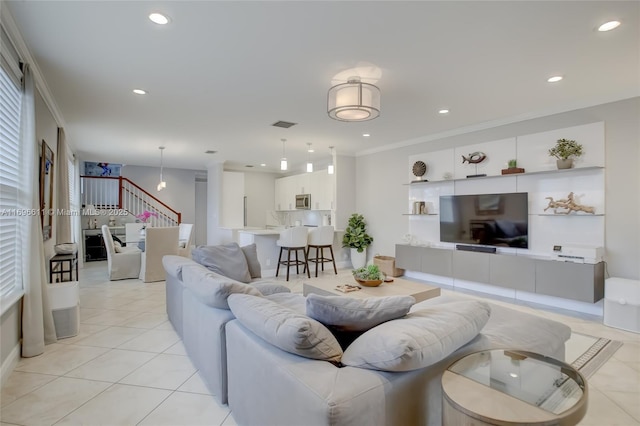 living room featuring crown molding and light tile patterned flooring