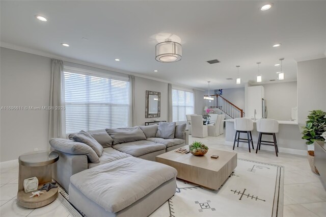 living room featuring crown molding and light tile patterned flooring