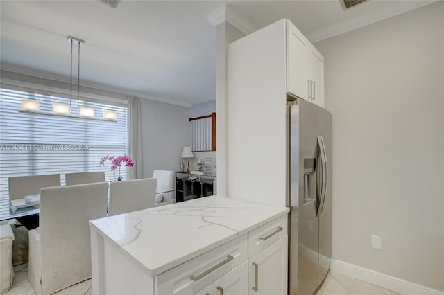 kitchen featuring hanging light fixtures, light stone countertops, white cabinets, and stainless steel fridge