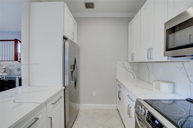 kitchen featuring light stone counters, white cabinets, and appliances with stainless steel finishes