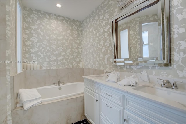 bathroom with tiled tub and vanity