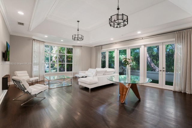 living room with french doors, a tray ceiling, ornamental molding, and dark wood-type flooring