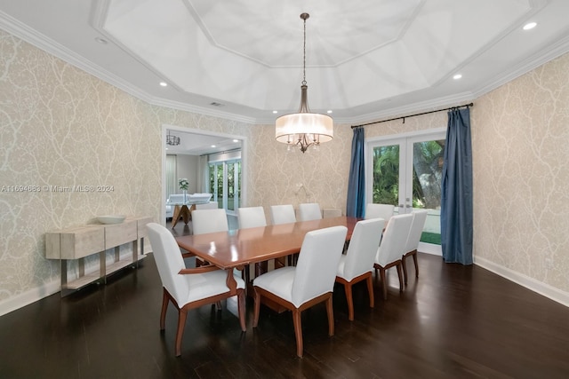 dining room featuring a raised ceiling, crown molding, french doors, and dark wood-type flooring