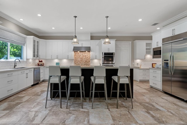 kitchen featuring built in appliances, a center island, hanging light fixtures, and sink