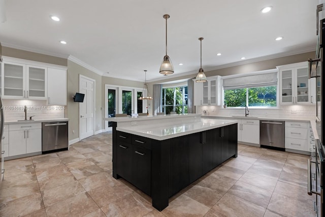 kitchen with stainless steel dishwasher, a kitchen island, white cabinets, and a wealth of natural light