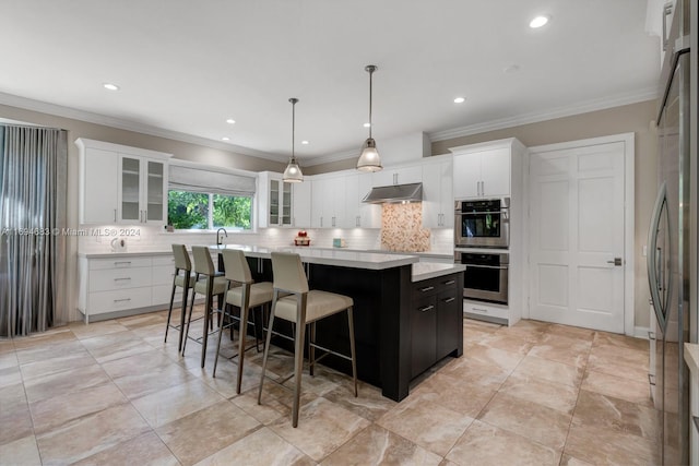 kitchen with white cabinetry, a center island, crown molding, pendant lighting, and appliances with stainless steel finishes