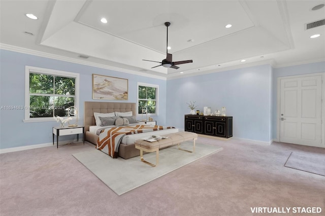 bedroom with ceiling fan, a tray ceiling, and multiple windows