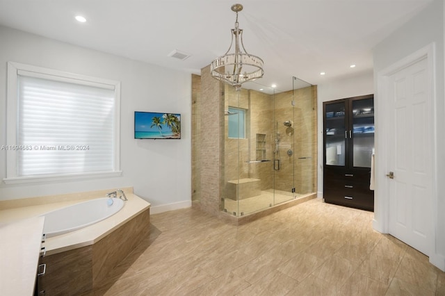 bathroom featuring a notable chandelier and shower with separate bathtub