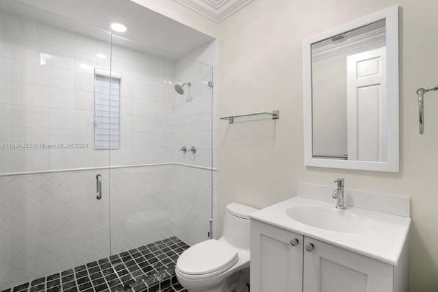 bathroom featuring toilet, vanity, a shower with shower door, and ornamental molding