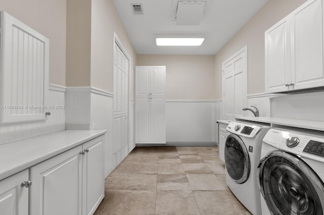 washroom with cabinets, light tile patterned floors, and washer and dryer