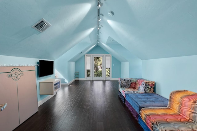 bedroom featuring track lighting, dark hardwood / wood-style floors, and vaulted ceiling