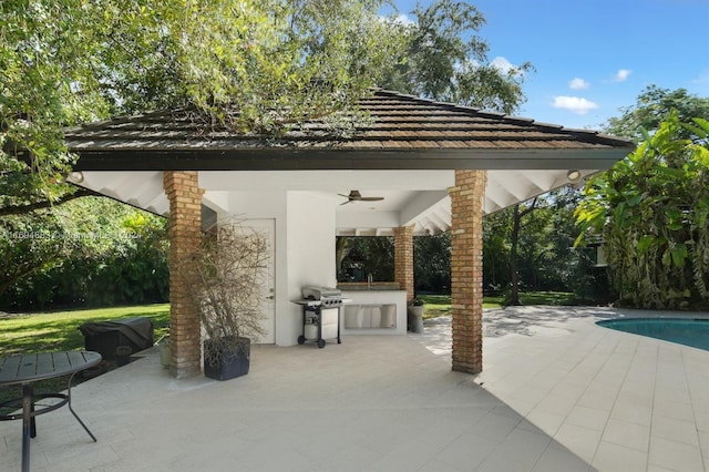 view of patio / terrace with a grill, ceiling fan, exterior bar, and exterior kitchen