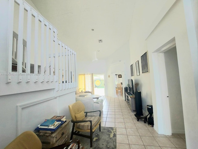 interior space featuring a towering ceiling and light tile patterned flooring