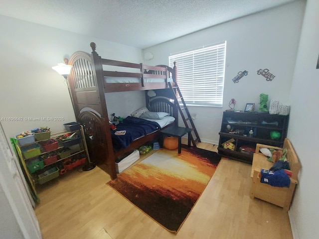 bedroom featuring wood-type flooring and a textured ceiling