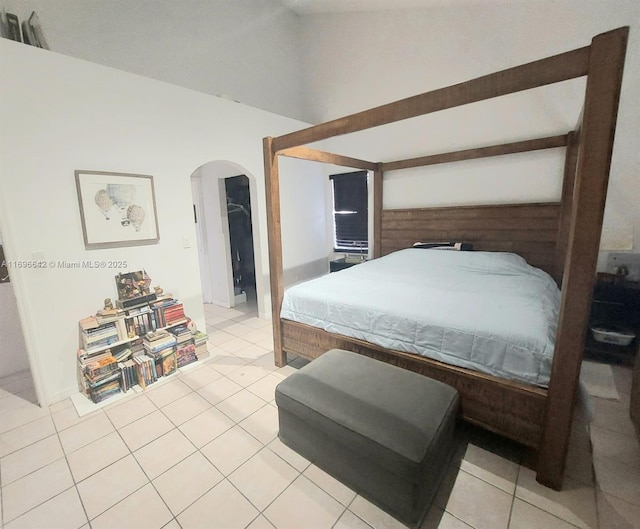 tiled bedroom featuring lofted ceiling