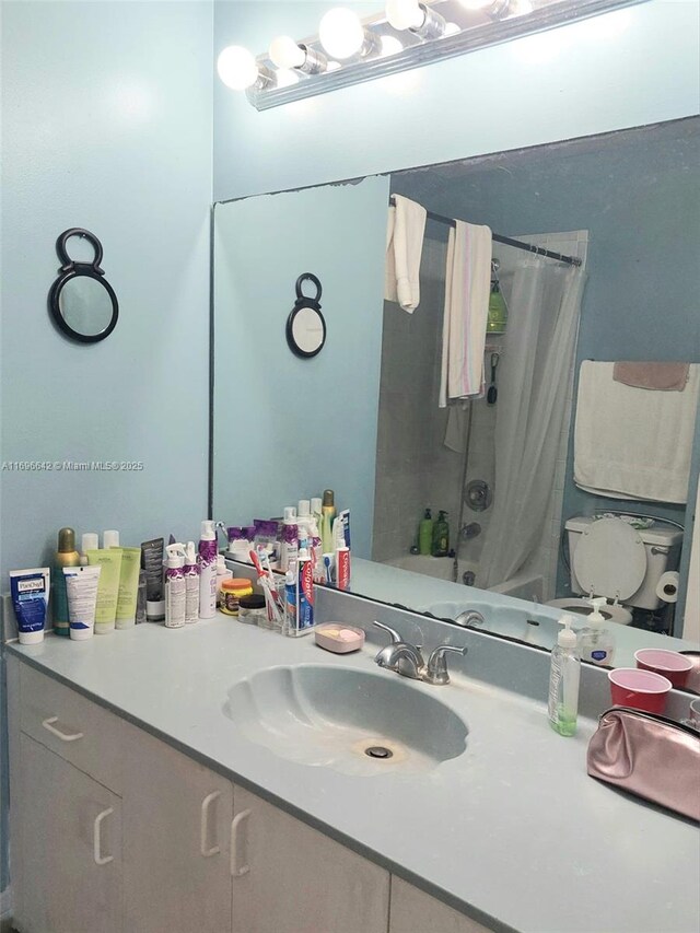 full bathroom featuring toilet, vanity, and shower / bath combo with shower curtain