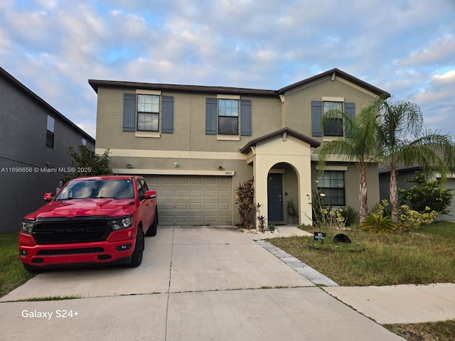 traditional home with a garage, concrete driveway, and stucco siding