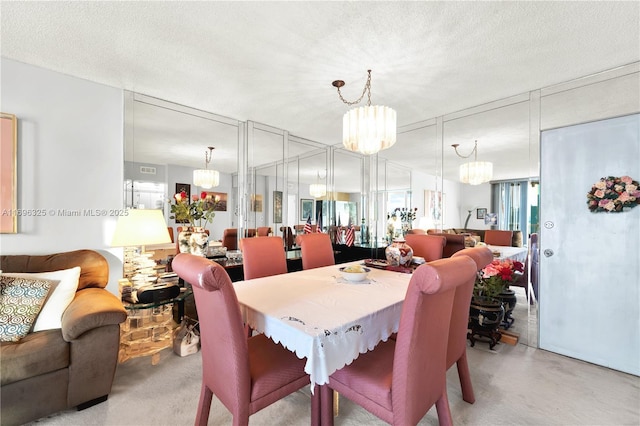 dining space with a chandelier and a textured ceiling