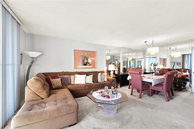 living area with a textured ceiling, carpet flooring, and an inviting chandelier