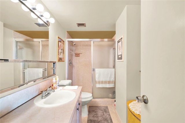 full bath with a stall shower, visible vents, vanity, and toilet