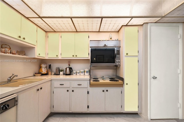 kitchen featuring cooktop, dishwasher, marble finish floor, light countertops, and a sink