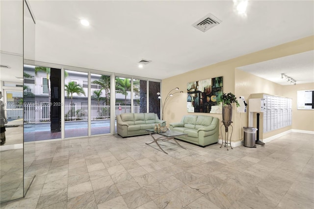 living area with baseboards, mail area, visible vents, and floor to ceiling windows