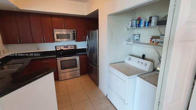 kitchen with sink, independent washer and dryer, stainless steel appliances, and light tile patterned floors