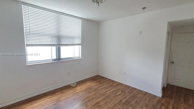 unfurnished room with dark hardwood / wood-style flooring