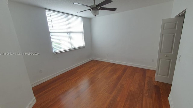 spare room featuring wood-type flooring and ceiling fan