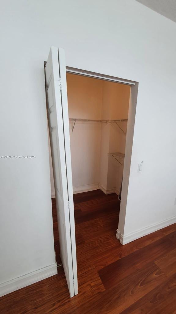 hallway with dark hardwood / wood-style flooring