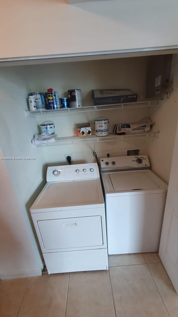 laundry area featuring washing machine and dryer and light tile patterned floors