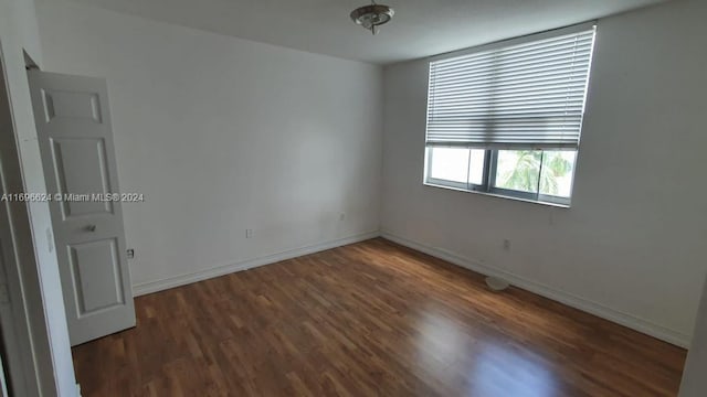 unfurnished room featuring dark wood-type flooring