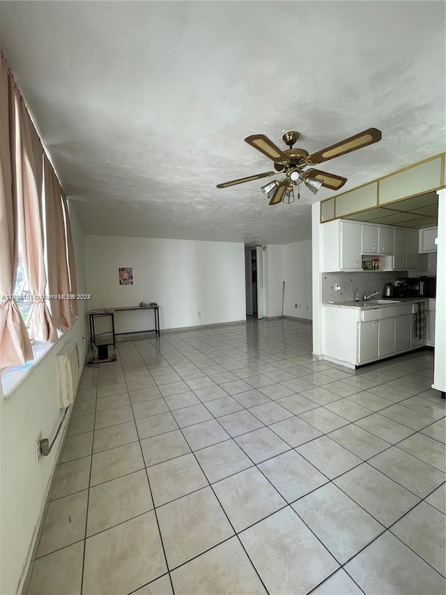 kitchen with backsplash, a textured ceiling, ceiling fan, light tile patterned floors, and white cabinetry