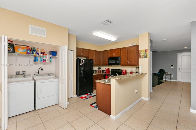 kitchen with black appliances, light tile patterned flooring, kitchen peninsula, and separate washer and dryer