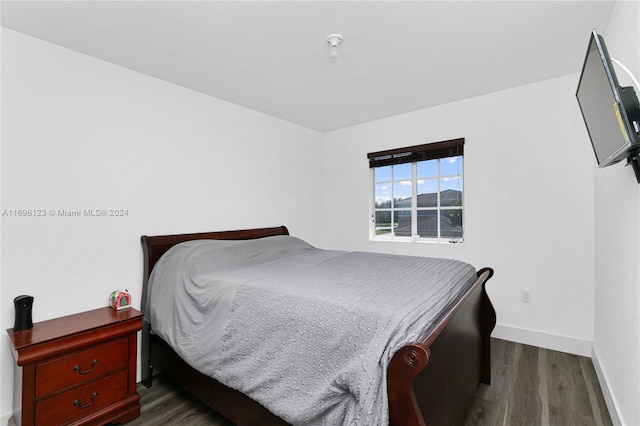 bedroom with dark hardwood / wood-style flooring