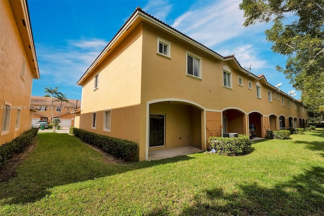 back of house with a patio area and a yard