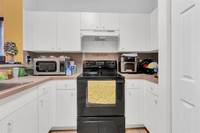 kitchen with white cabinetry, electric range, and light tile patterned floors