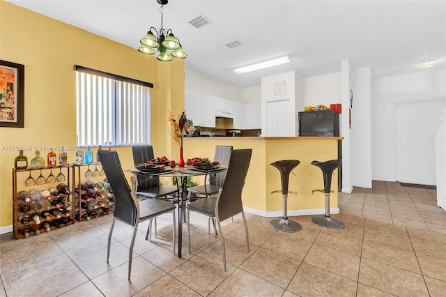 tiled dining space featuring an inviting chandelier