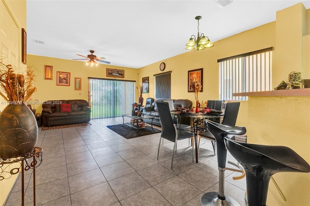 dining area featuring tile patterned flooring and ceiling fan with notable chandelier