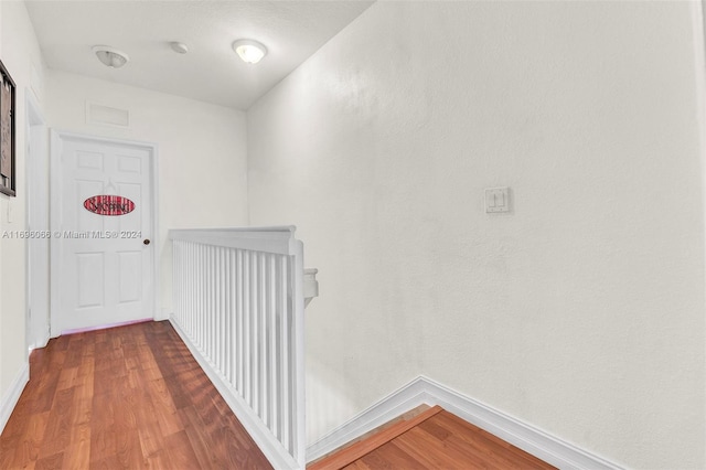 hallway with hardwood / wood-style floors