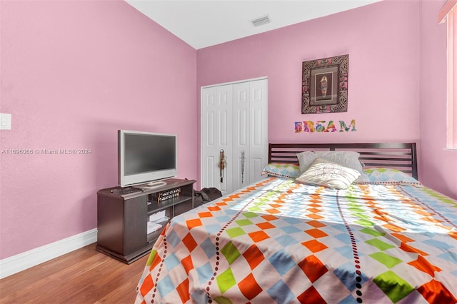 bedroom with light hardwood / wood-style floors and a closet