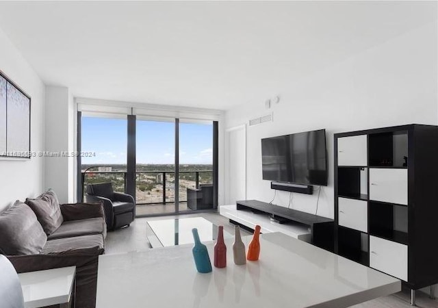 living room with plenty of natural light, a wall of windows, and light hardwood / wood-style flooring