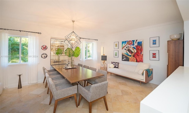 dining room featuring a healthy amount of sunlight, ornamental molding, and a chandelier