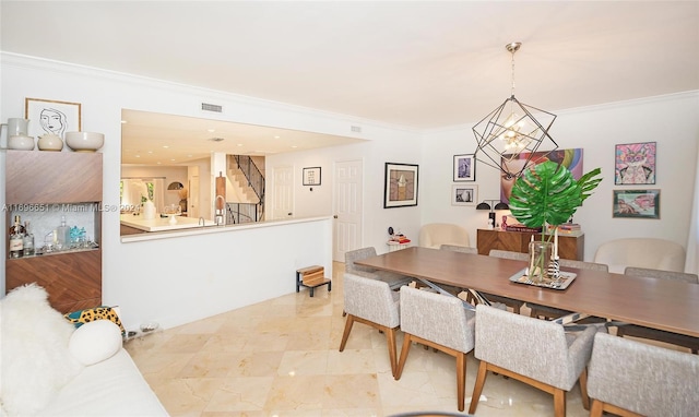 dining space with ornamental molding and a chandelier