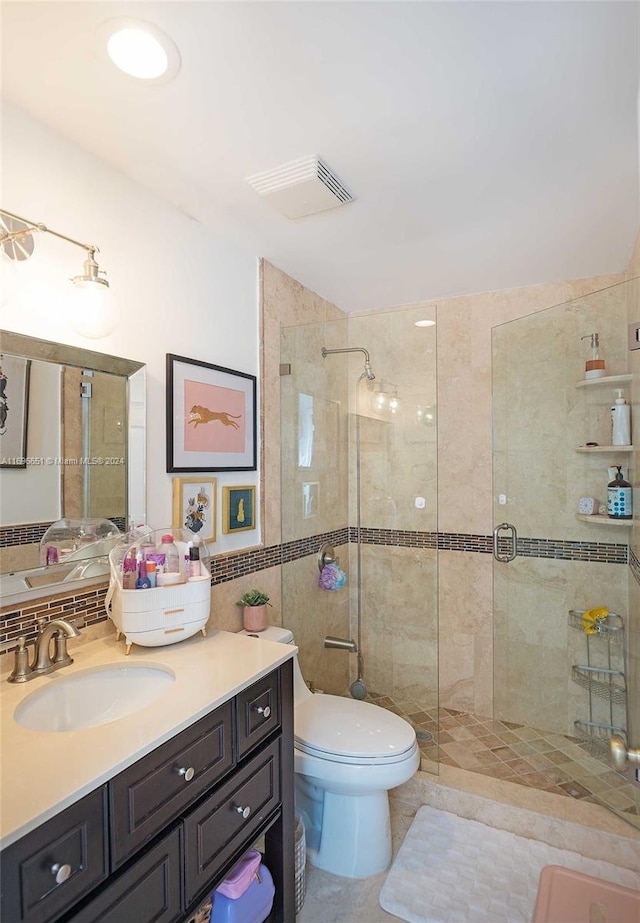 bathroom featuring vanity, toilet, walk in shower, and tile walls