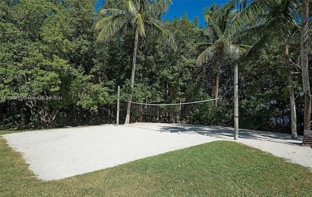 view of property's community with a lawn and volleyball court